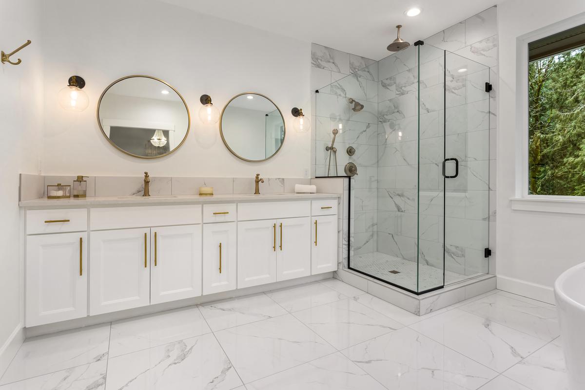 A Bathroom Vanity With Wooden Cabinetry and Brass Handles that Says Clean, Classy, and Cool