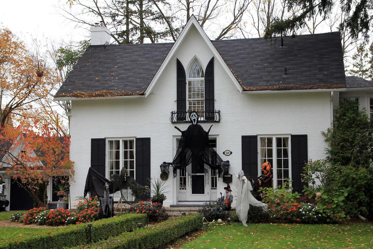 Adorn your house with eerie outdoor Halloween decorations, featuring spooky ghosts and scarecrows.