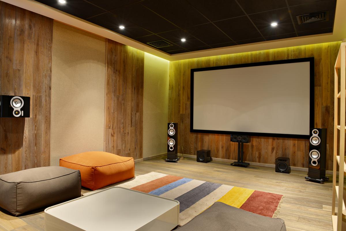 A combination of wood paneling and bright colors makes for a unique, positively eclectic home theater design.