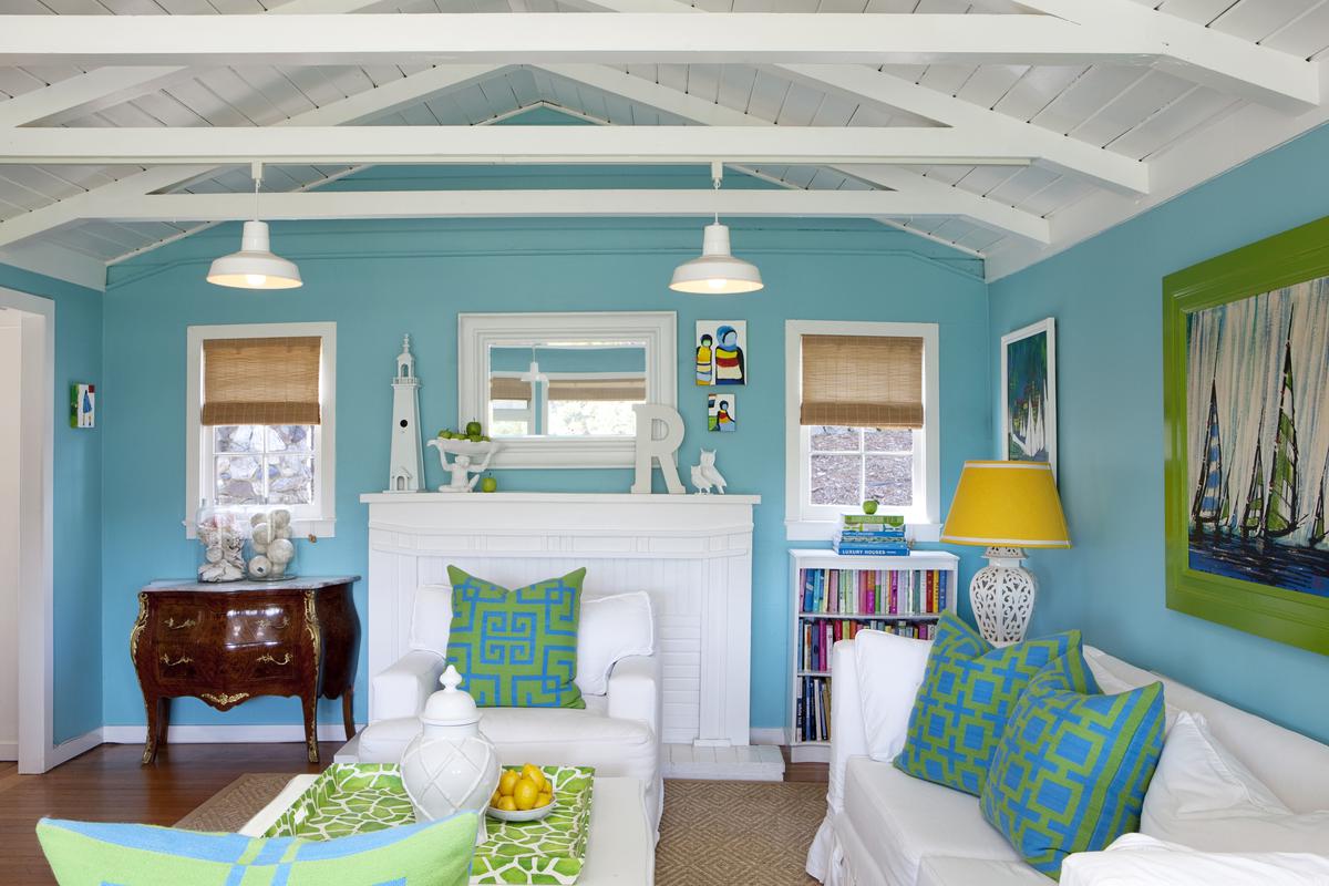 Vibrant paintings and patterned throw pillows accentuate the color palette of the living room.