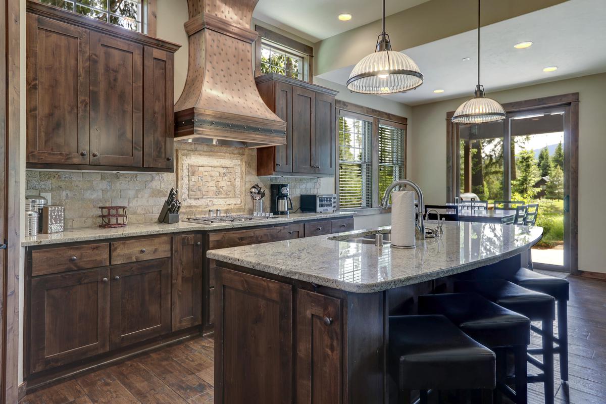 Natural stone backsplashes and stone countertops add layering to the design.